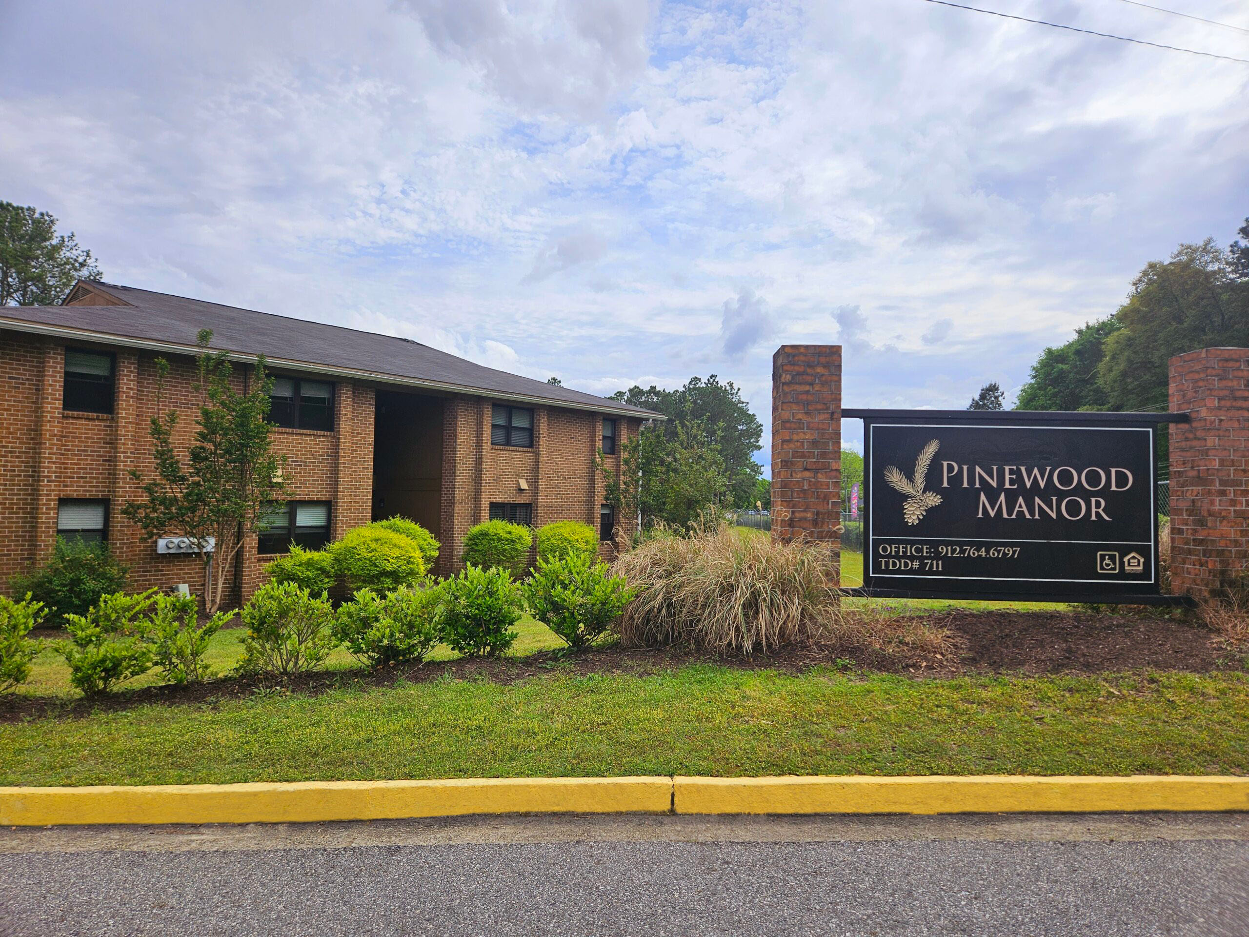 Outside sign showing curb Belle Courts Apartments
